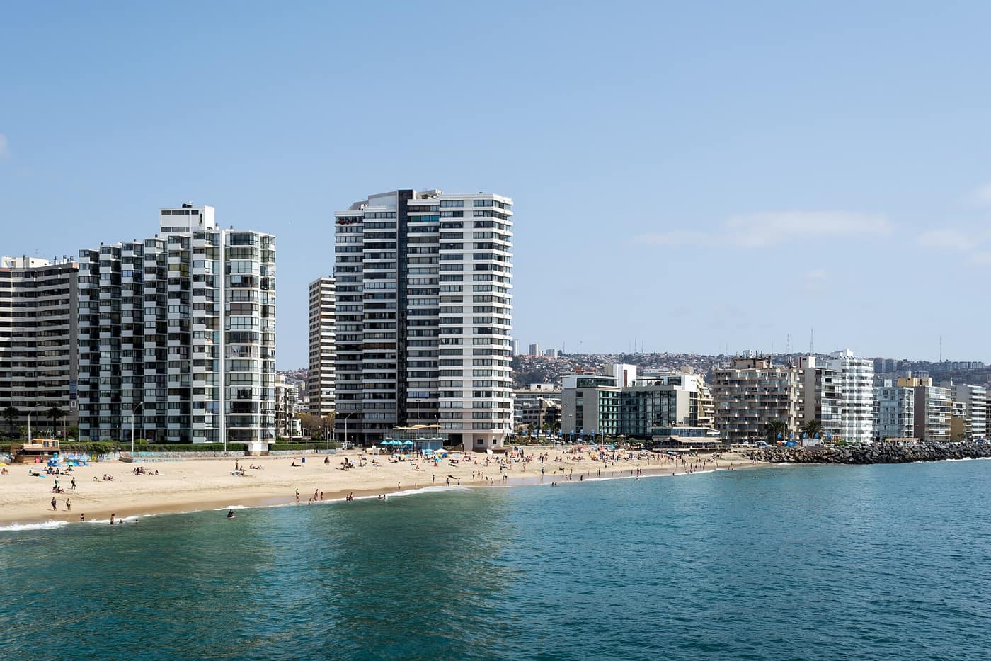 Der Strand Playa Acapulco in Viña del Mar mit goldenem Sand, türkisem Wasser und Hochhäusern dahinter